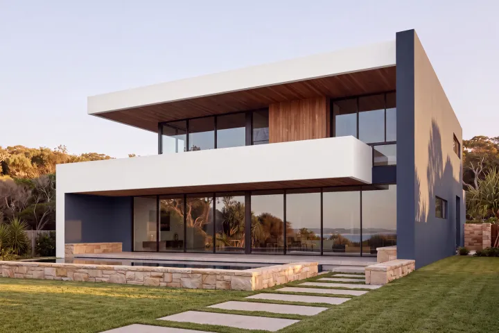 The home with the tall end wall and terrace wall in Dulux Pacific Line navy and the bands in Vivid White.